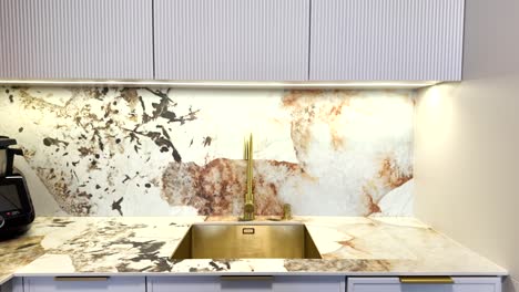 modern kitchen with gold fixtures and marble countertops