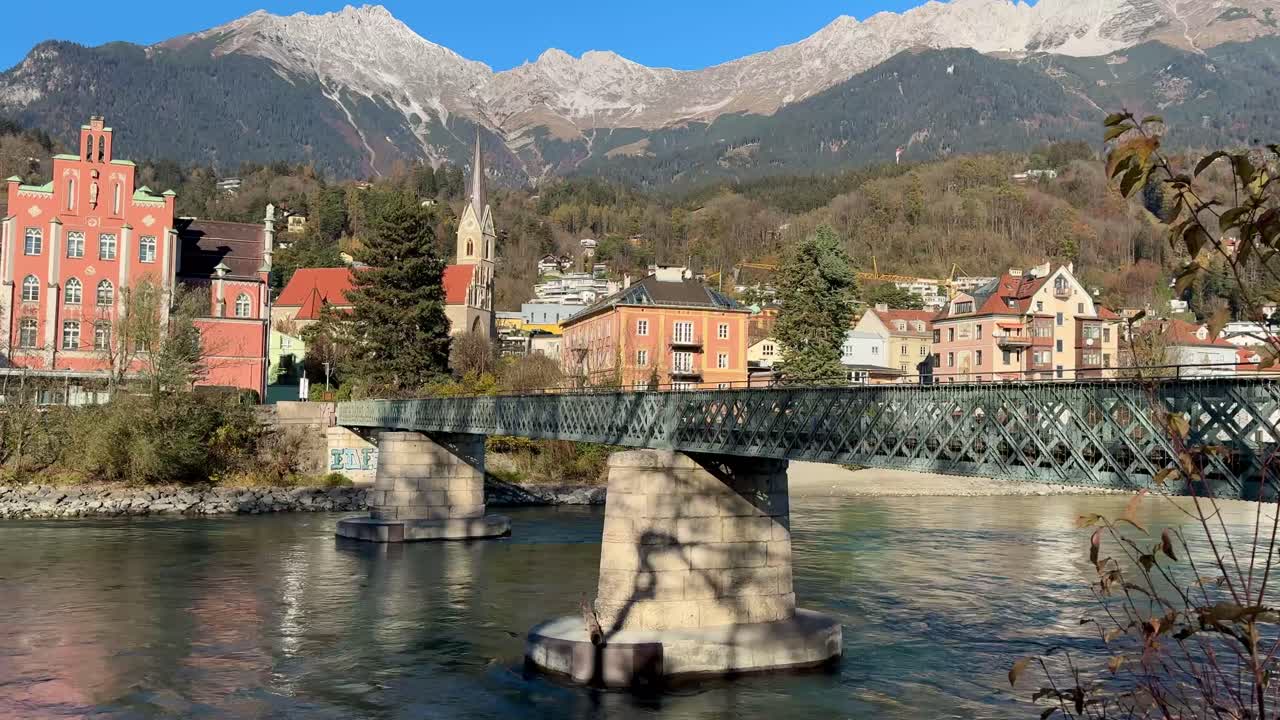 People cross scenic pedestrian bridge in Innsbruck.