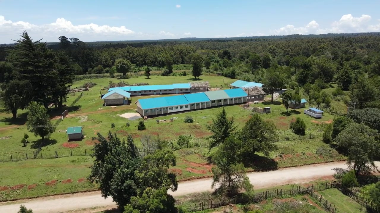 Cảnh quay drone con đường bụi bặm và tòa nhà đang xây dựng ở Kaptagat, Kenya, Châu Phi