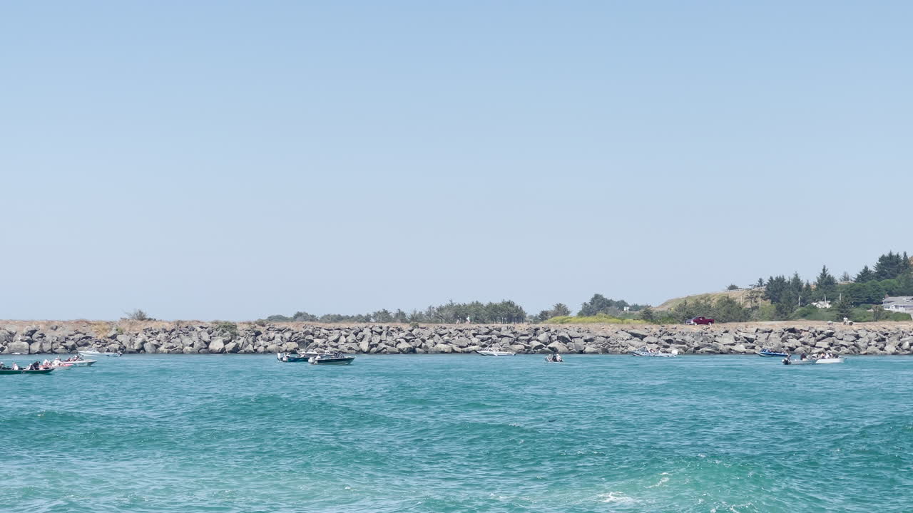 오레곤 골드 비치에서 연어 낚시를 하는 사람들과 준설선과 보트