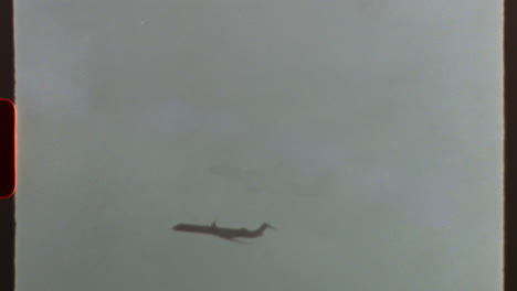 filmed on super 8 film - airplane flying in a cloudy sky, with a retro 8mm or super 8 film effect and light leaks, creating a nostalgic and classic aesthetic