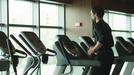 Sporty-athlete-warming-up-in-sport-club.-Fit-man-running-on-treadmill-at-gym