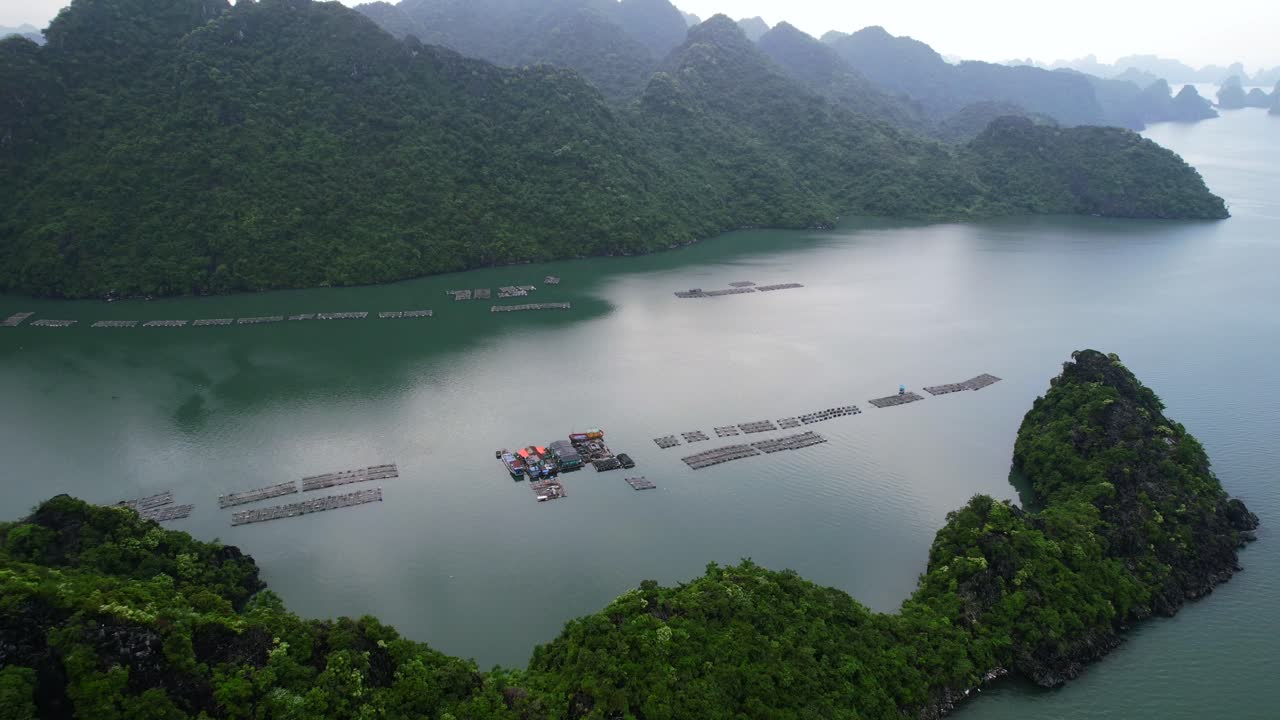 석회암 절벽으로 둘러싸인 베트남 하롱베이 굴 양식장이 있는 수상 마을 공중