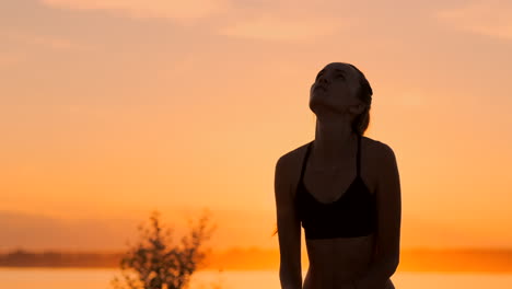 athletic girl playing beach volleyball jumps in the air and strikes the ball over the net on a beautiful summer evening. caucasian woman score a point.