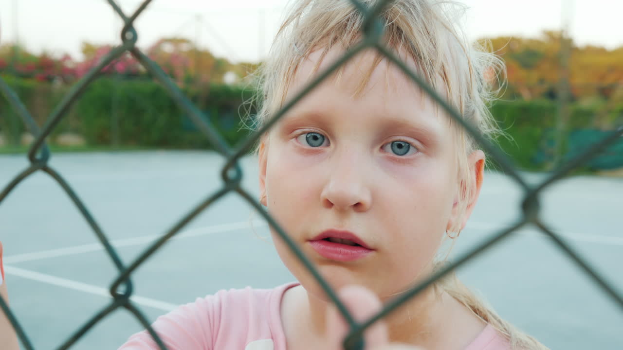 울타리 메쉬를 통해 보고 피곤한 아이