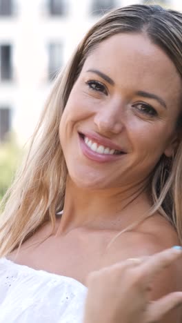 happy woman playing with long blond hair in park during daytime