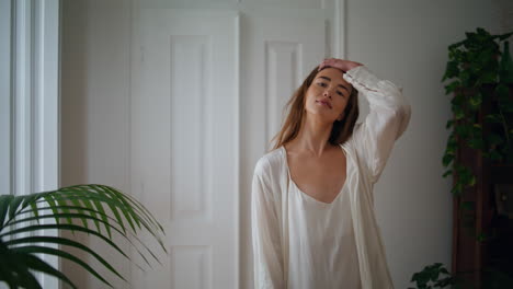 Dreaming-lady-looking-window-cozy-interior.-Tender-woman-touching-hair-enjoying