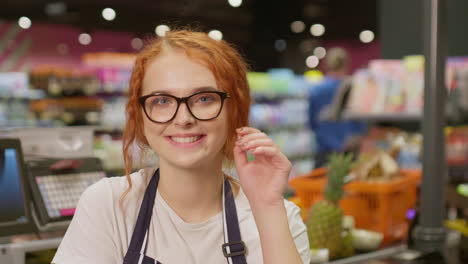 young sales clerk woman smiling and looking at the camera in a supermarket