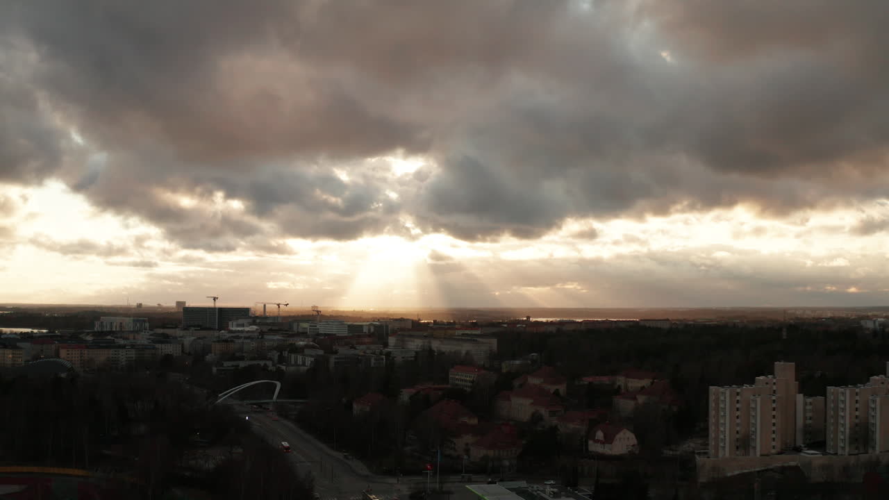 Aerial shot of cityscape on a cloudy day, with dramatically illuminated sky