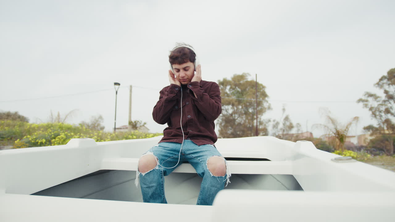 Man Listening To Music On A Boat On The Shore