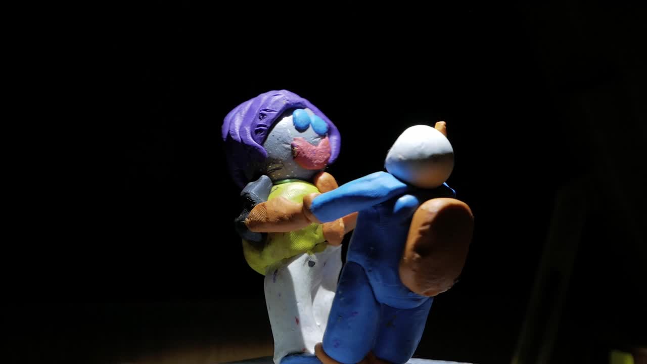 손을 잡고 함께 회전하는 두 친구의 폴리머 클레이 그림 - 우주 개념의 캐릭터 - 스튜디오 샷