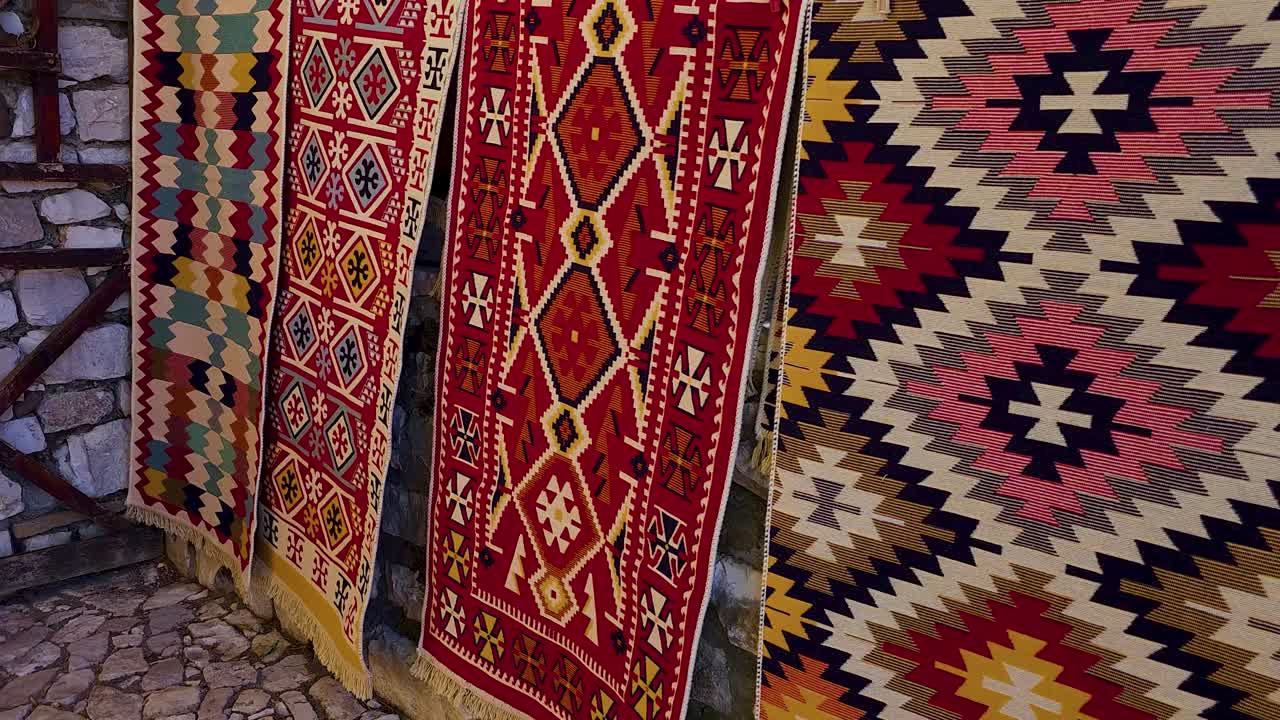 Tappeti adornano le mura in pietra del Castello di Berat, arazzi artigianali fatti a mano di colori e forme in Albania