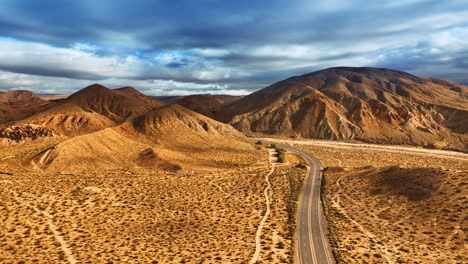 beautiful bare mountains in the desert of nevada. highway with cars in the dry landscape from top view.