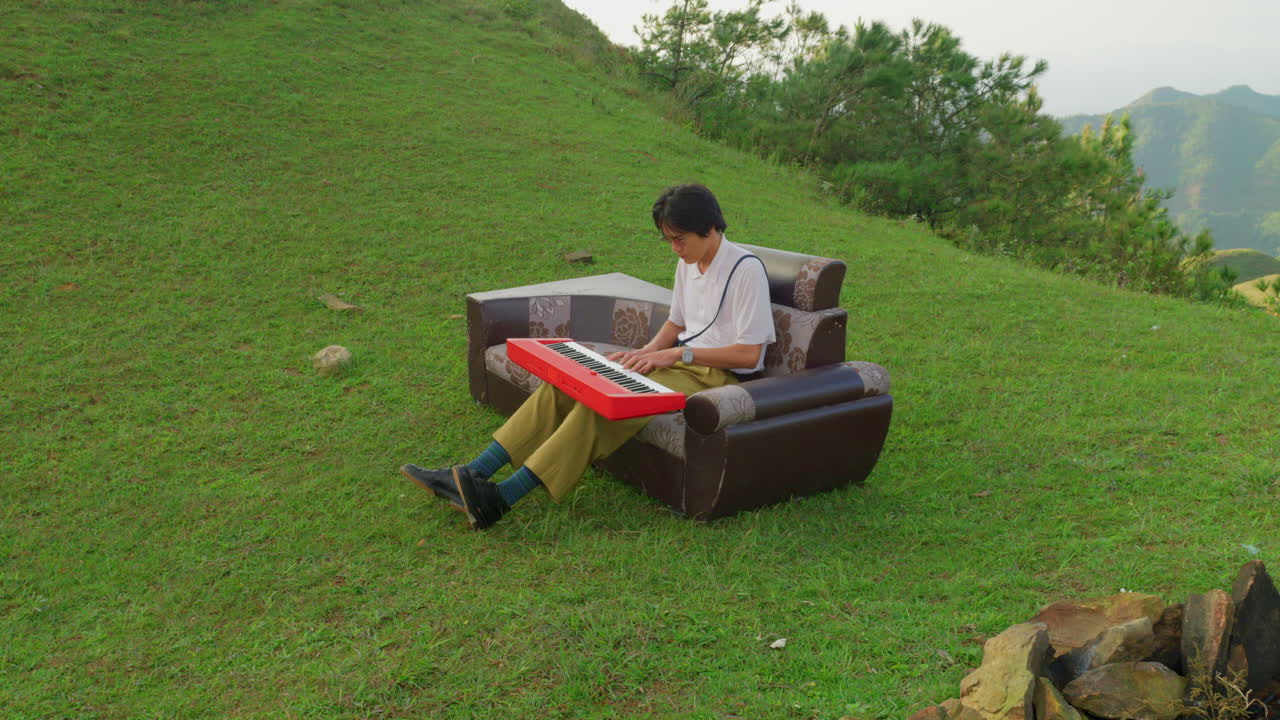 Man Playing Keyboard on a Hilltop
