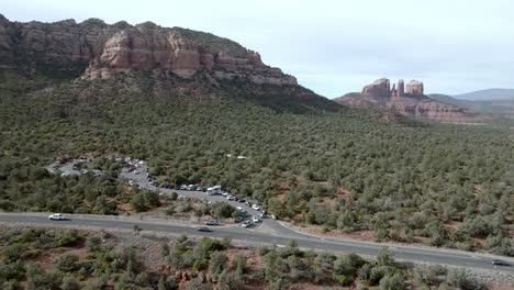 montañas de roca roja y buttes en sedona, arizona con coches conduciendo en la carretera con video de avión no tripulado amplia toma estable