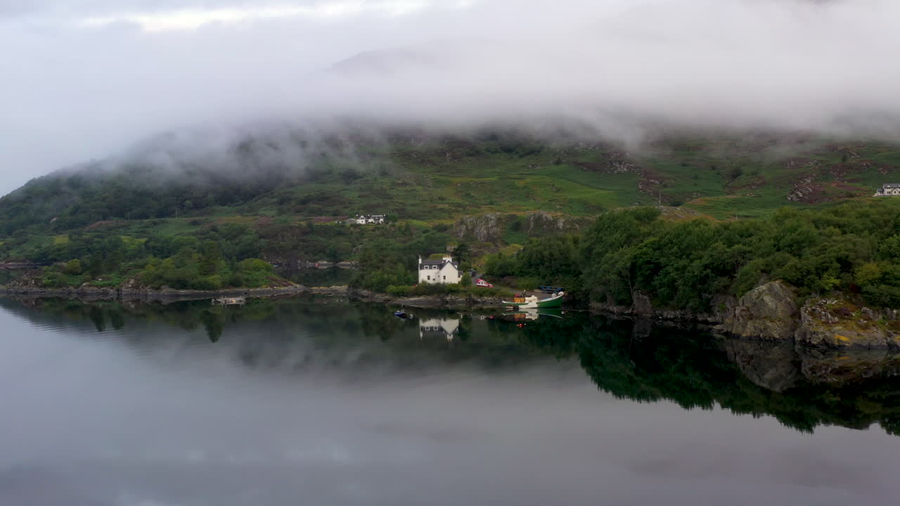 스코틀랜드 고원의 로스와 크로마티 서쪽 해안에 있는 카론 호수에 있는 작은 집이나 생선 집의 회전 드론 샷