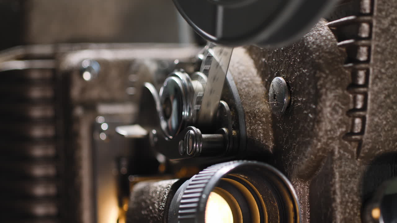 macro de cerca de una cinta de película de 8 mm pasando por un viejo proyector analógico de 8 mm