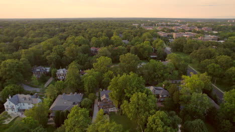 pan left over beautiful clayton neighborhood houses and trees with downtown skyline on horizon at sunset