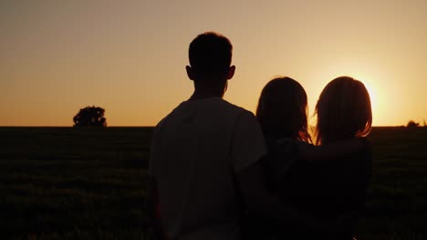 young family with a child looking at a beautiful sunset