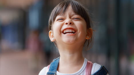 Portrait-Of-Smiling-Female-Elementary-School-Pupil-Outdoors-With-Backpack-At-School