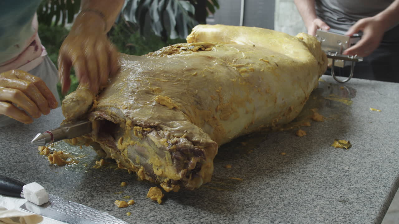 로스터 창에 보조 바늘 전체 양고기를 가진 요리사