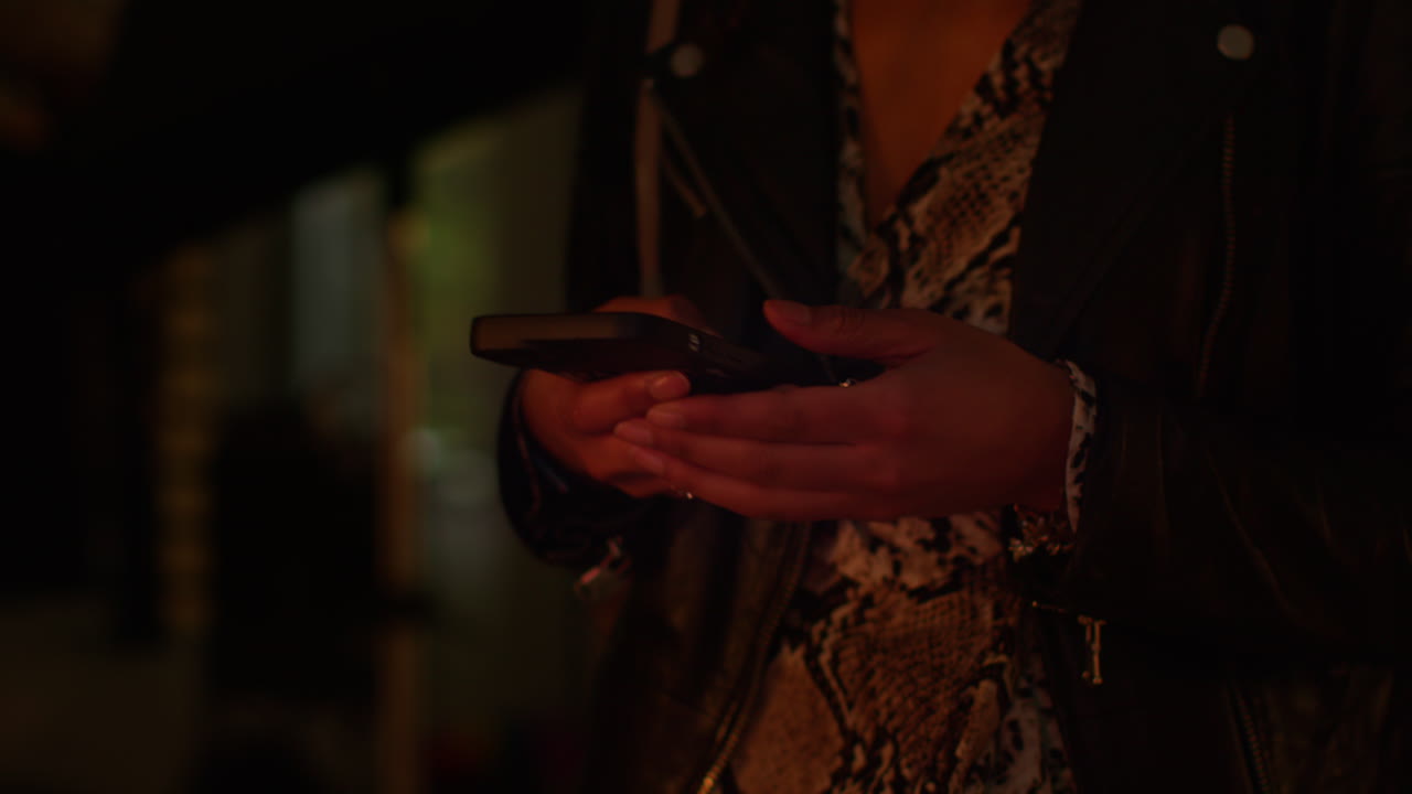 밤에 방에서 스마트폰을 사용하는 여성