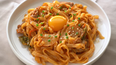 stir-fried udon noodles with kimchi and pork - korean food style