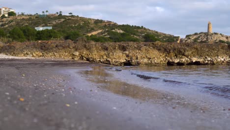 Una-Pequeña-Playa-Con-Un-Faro-Al-Fondo