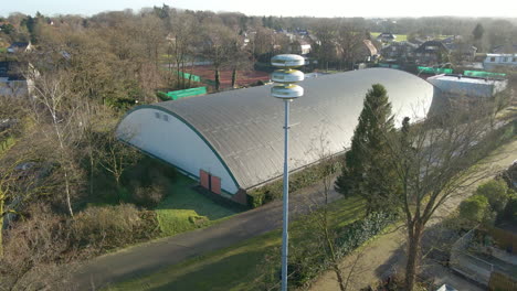 Dirty-Dutch-air-raid-siren-on-a-pole-in-the-Netherlands---drone-flying-away