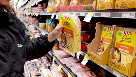 person picking product from supermarket shelf