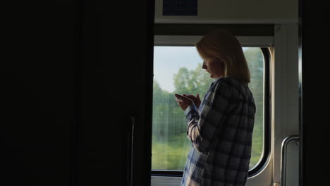 a young traveler uses a smartphone in the train car