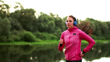 a morning jog in the park near the pond in the sunny rays of dawn, the girl is preparing to mariano and lead a healthy lifestyle