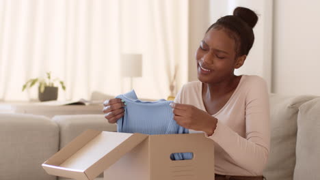 excited woman unboxing a blue sweater