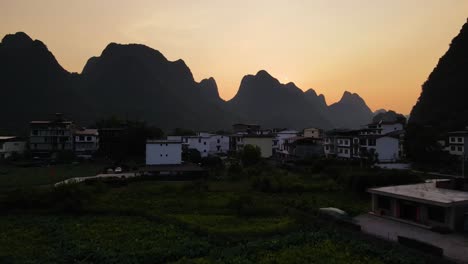 Ciudad-De-Guilin-Yangshuo-En-Un-Hermoso-Paisaje-De-Montaña-Al-Atardecer,-Vuelo-De-Establecimiento-Aéreo