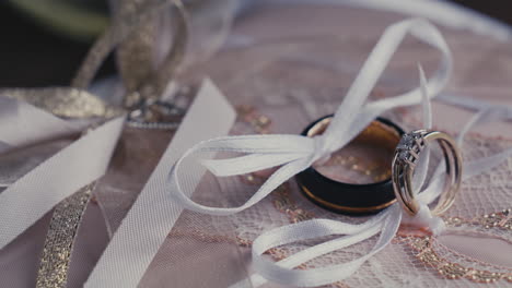 close up of a pair of precious wedding rings tied with ribbon