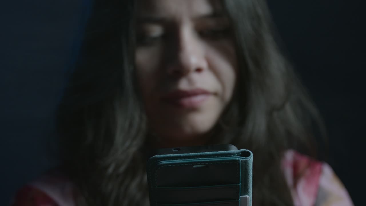 Intimate close-up shot of a young girl smirking while engaging with her smartphone. Dim lighting creates a subtle, mysterious mood. Focused on the face and device, conveying intrigue