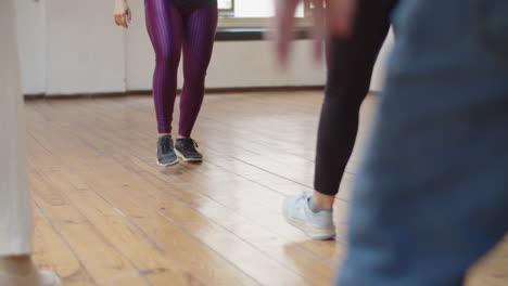 primer plano de las piernas de los bailarines aprendiendo paso de baile en el estudio