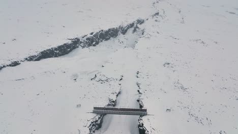 Levantándose-En-El-Puente-Entre-Continentes-Durante-Una-Tormenta-De-Nieve-En-La-Península-De-Reykjanes,-En-El-Sur-De-Islandia