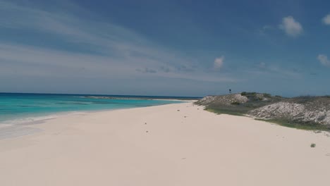 Pareja-Bañándose-En-Una-Solitaria-Playa-Caribeña-Rodeada-De-Arena-Blanca-Y-Agua-Turquesa,-Tiro-De-Drones-En-La-Isla-De-Los-Roques