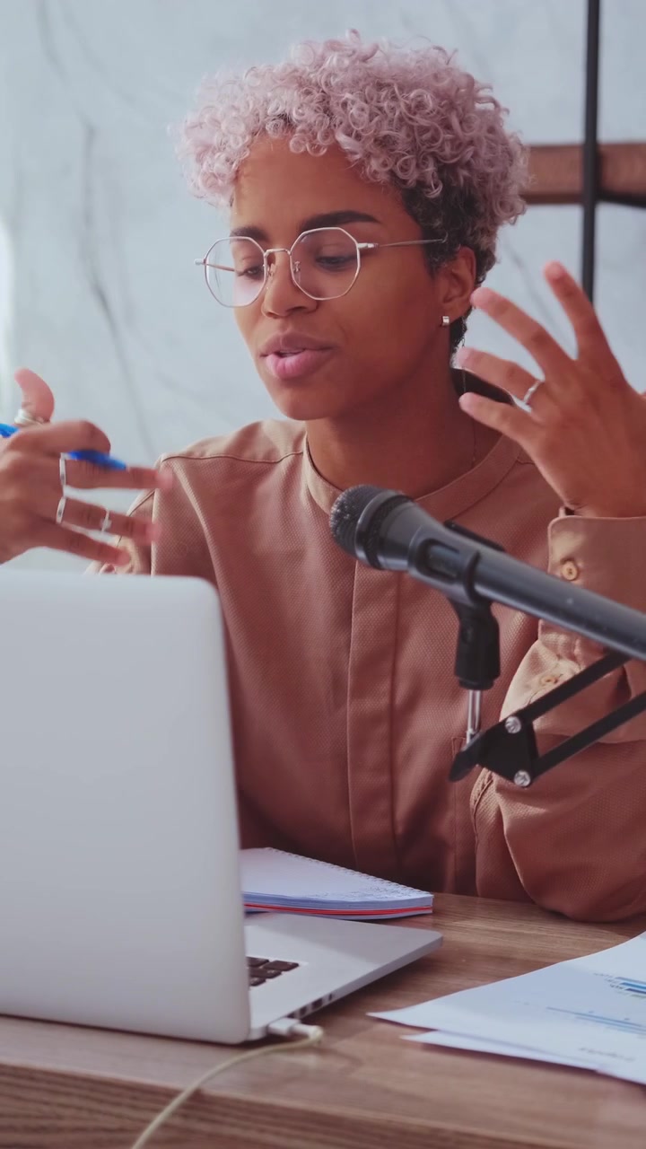 African american woman recording a podcast or vlog in a modern studio