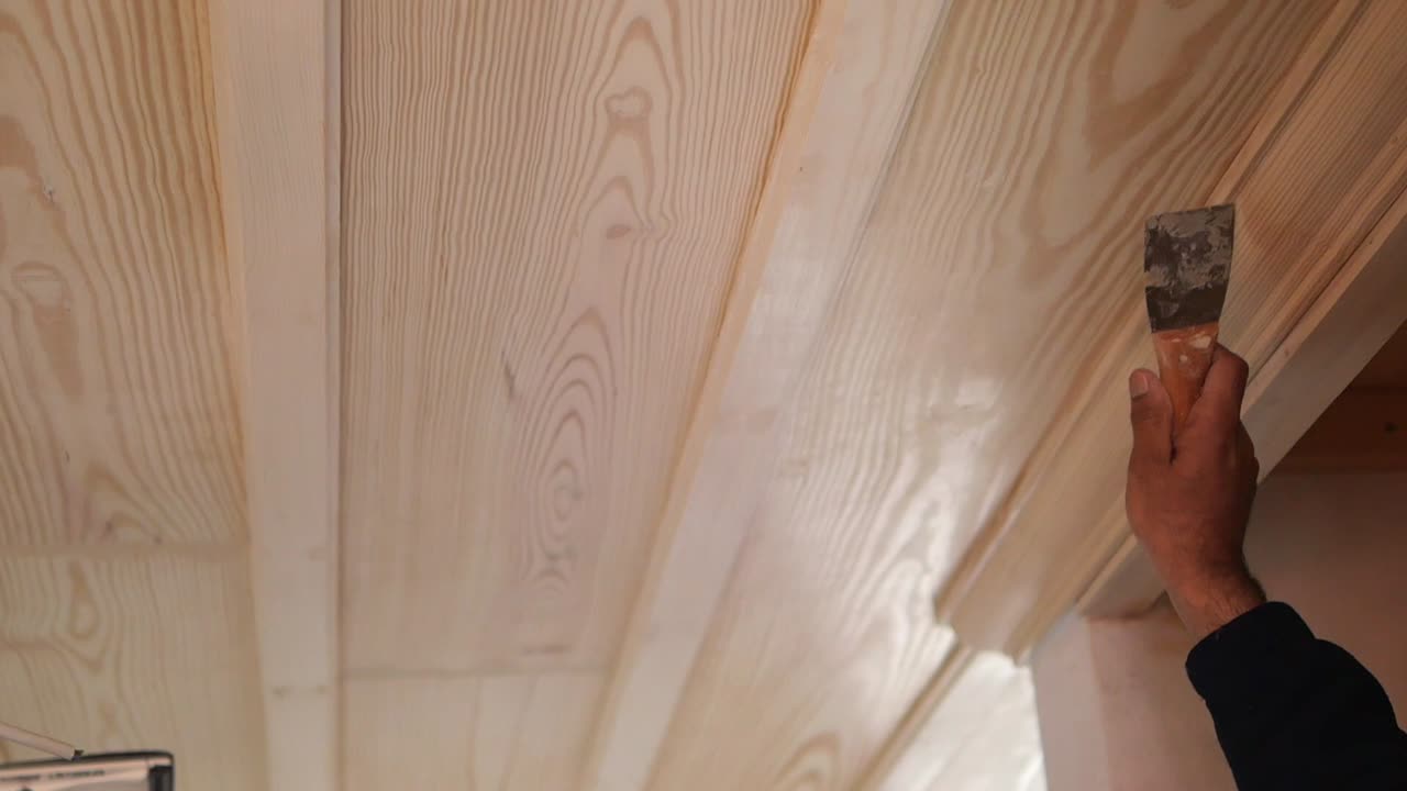 Applying sealant to wooden ceiling paneling