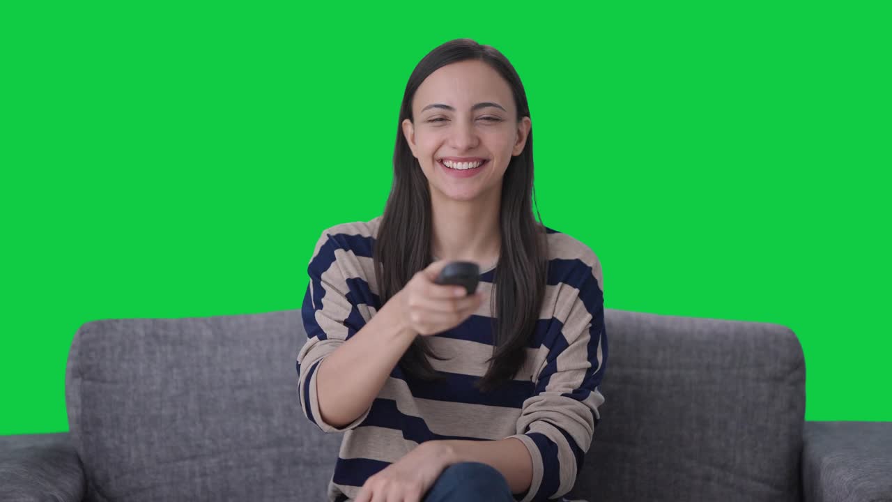 Ragazza indiana felice che guarda la TV Schermo verde