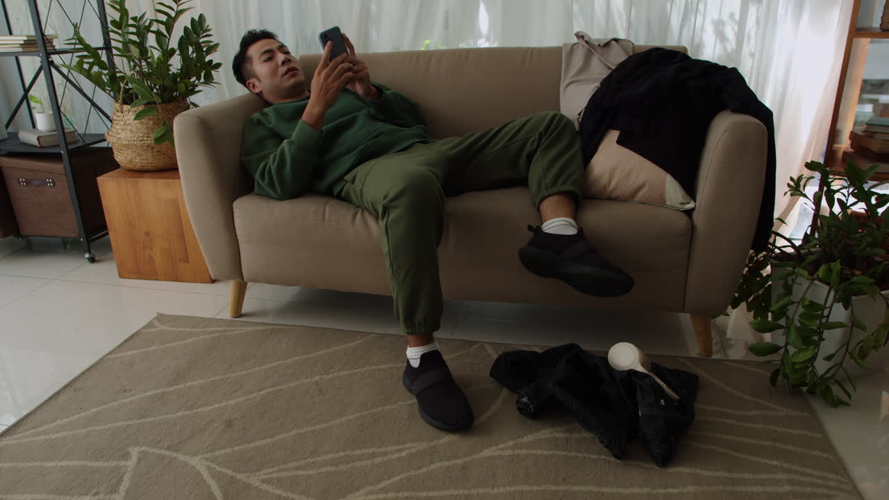 소파에 누워 있는 슬픈 남자