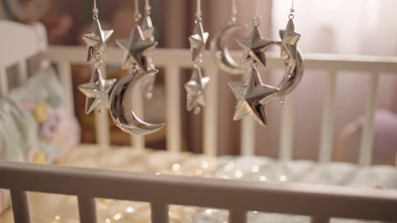 Charming Silver Star and Crescent Moon Mobile Hanging Above a Cozy Crib, Creating a Dreamy Atmosphere for a Baby's Nursery