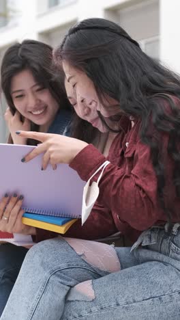 three asian girl students talking at break time sitting on campus