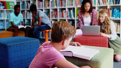 niños de la escuela haciendo la tarea en la biblioteca