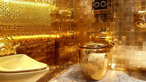 a bathroom with a gold sink and a toilet