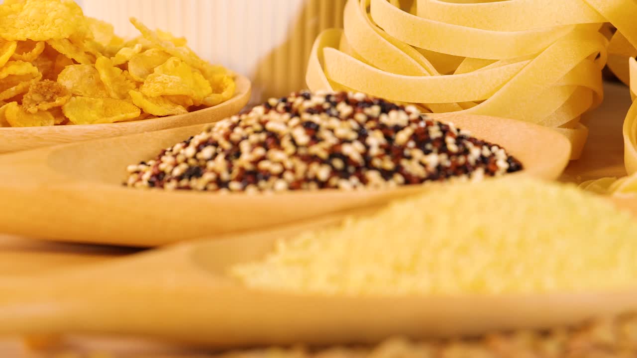 A variety of grains, pasta, and bread arranged in a warm, well-lit setting, highlighting textures and colors