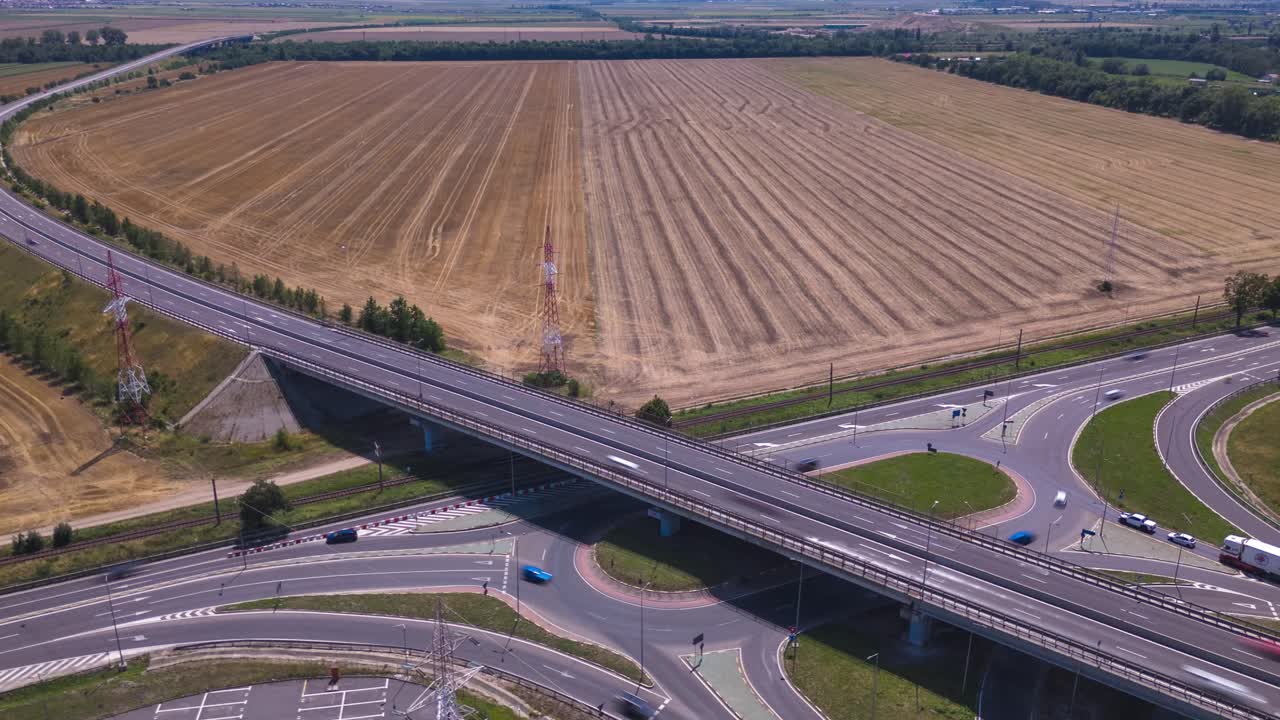 Drone hyperlapse video of fast-moving cars on the E574 road, with an open agricultural area near Brașov