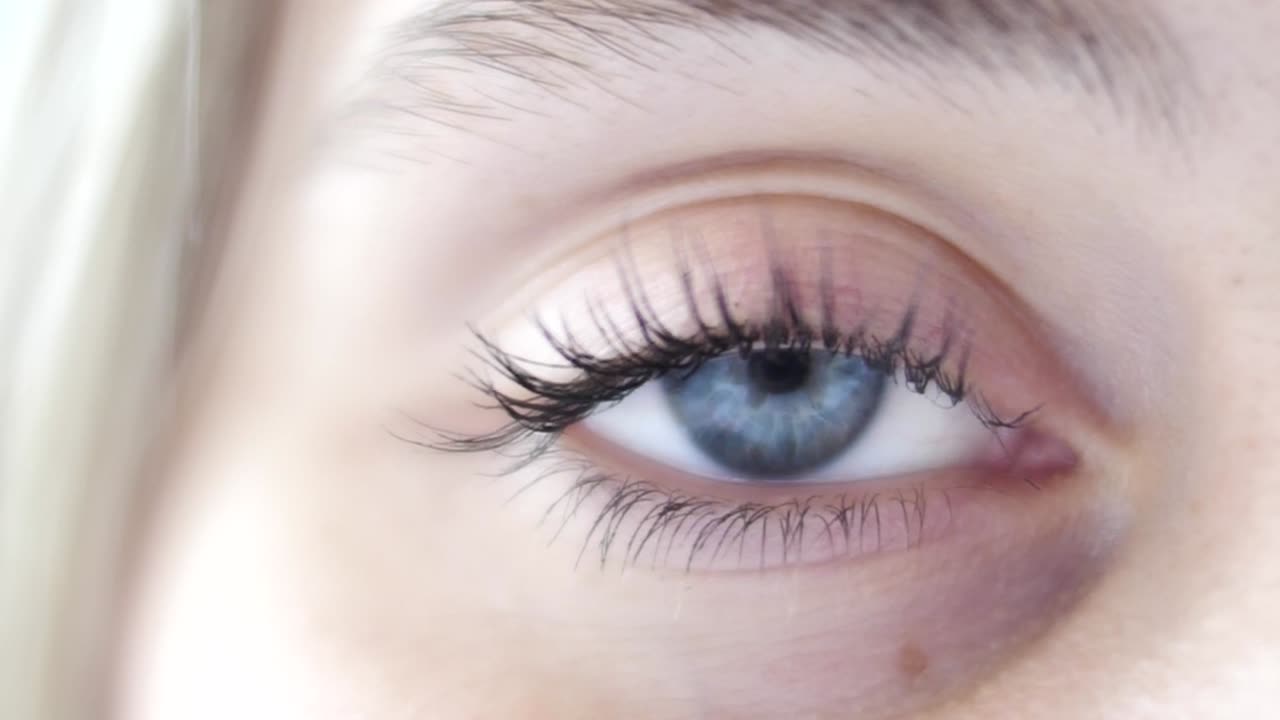 la mujer abre el ojo azul de cerca